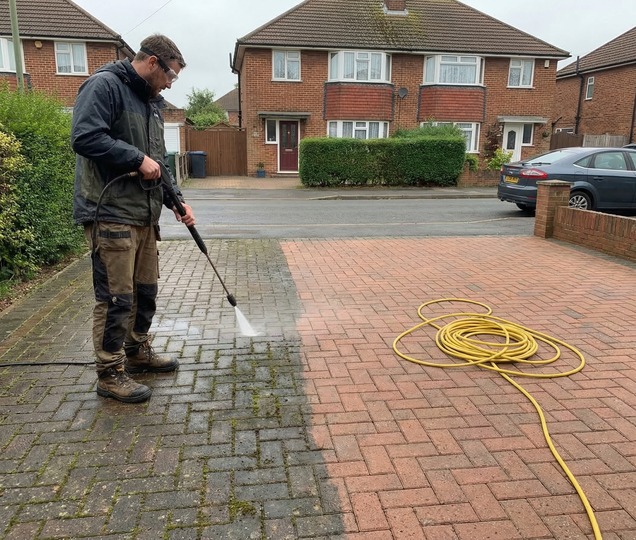 Exterior cleaning technician restoring a domestic driveway surface with controlled pressure washing.