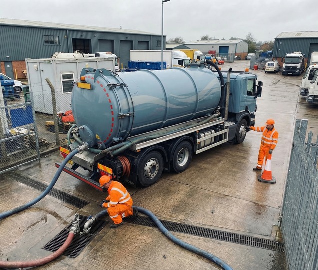 Vacuum tanker operator coordinating liquid waste removal at a managed service location.